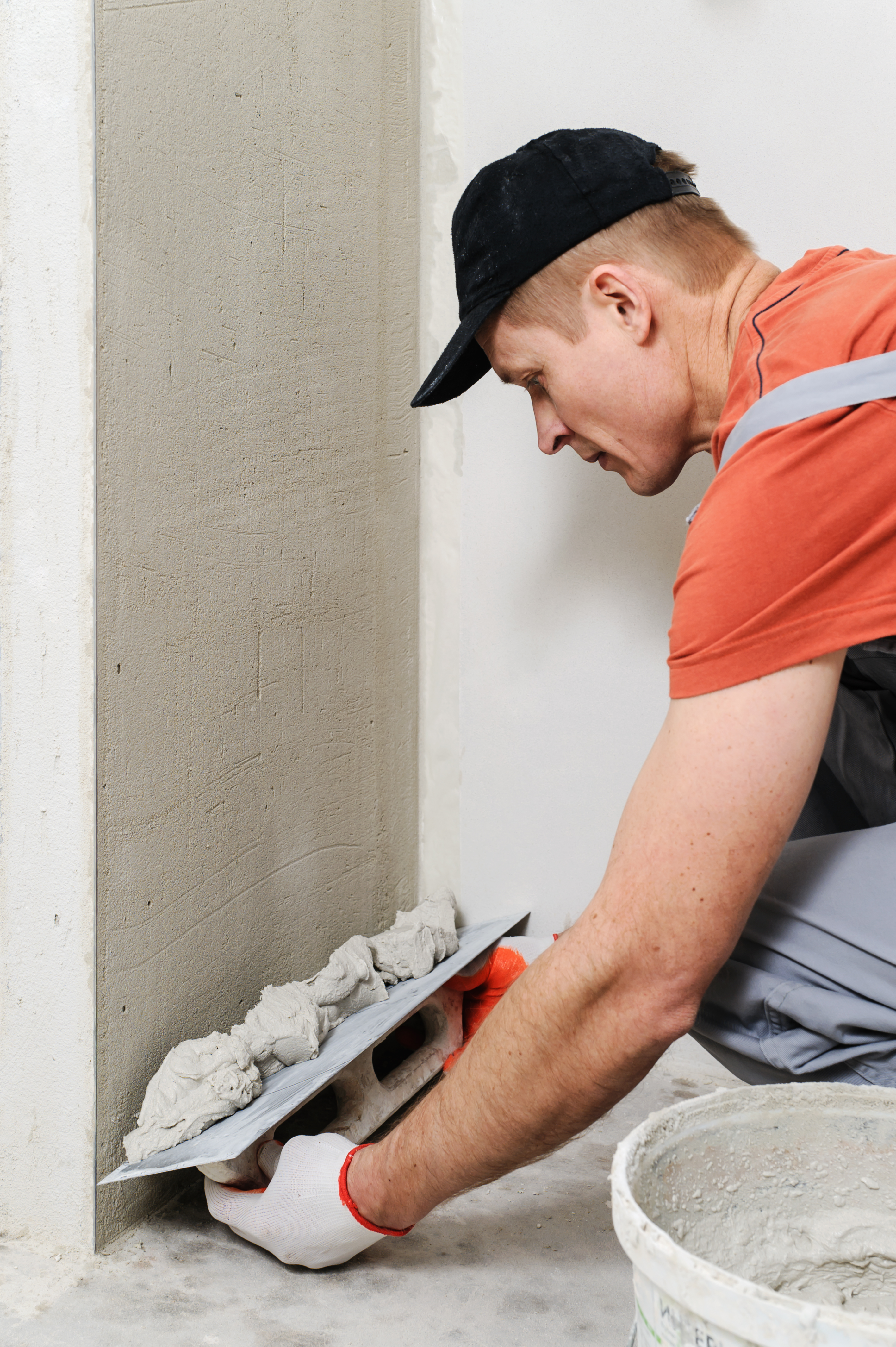 Plasterer at indoor wall renovation decoration with float and plaster