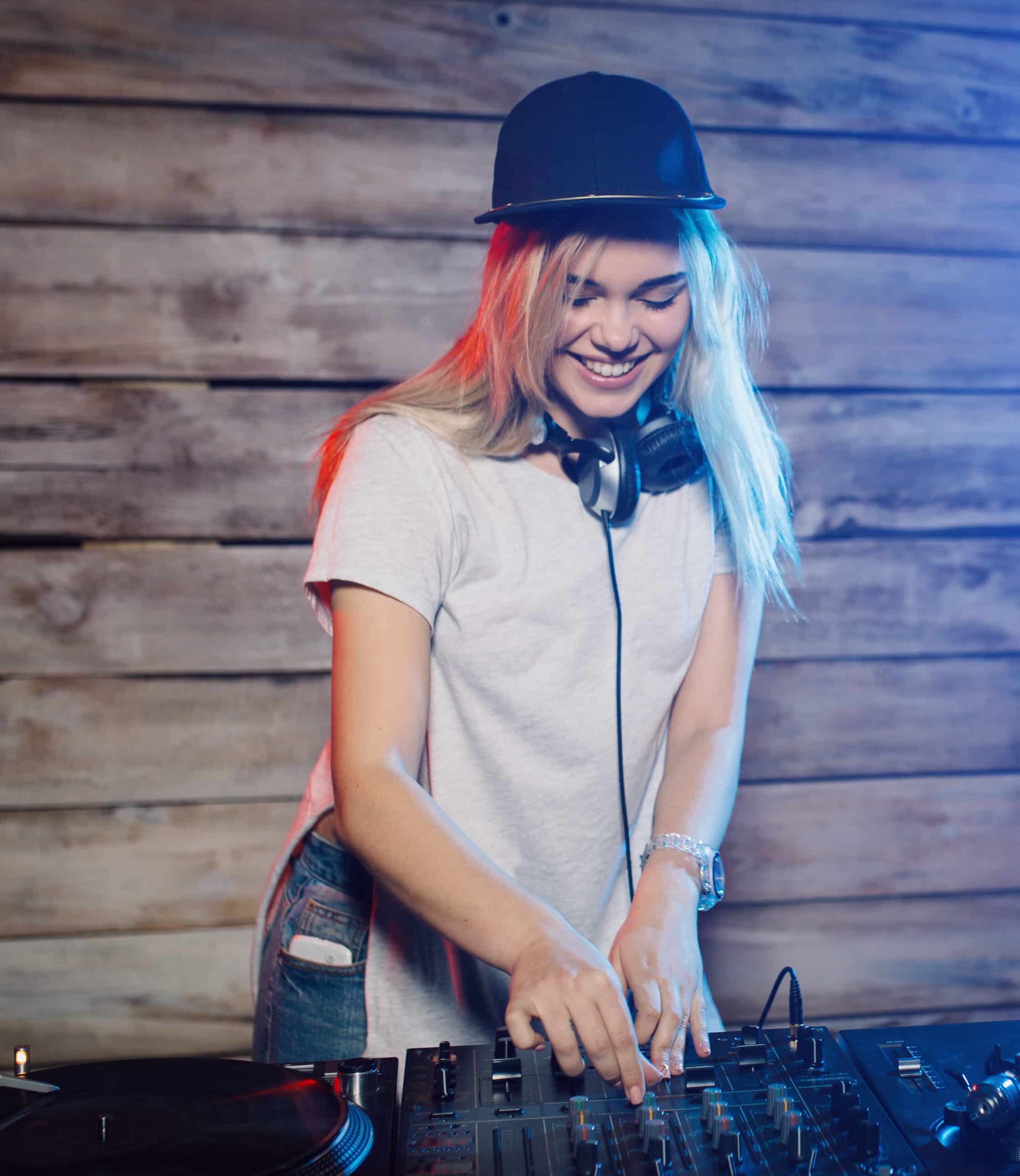 Cute dj woman having fun playing music on vinyl record deck at club party nightlife lifestyle