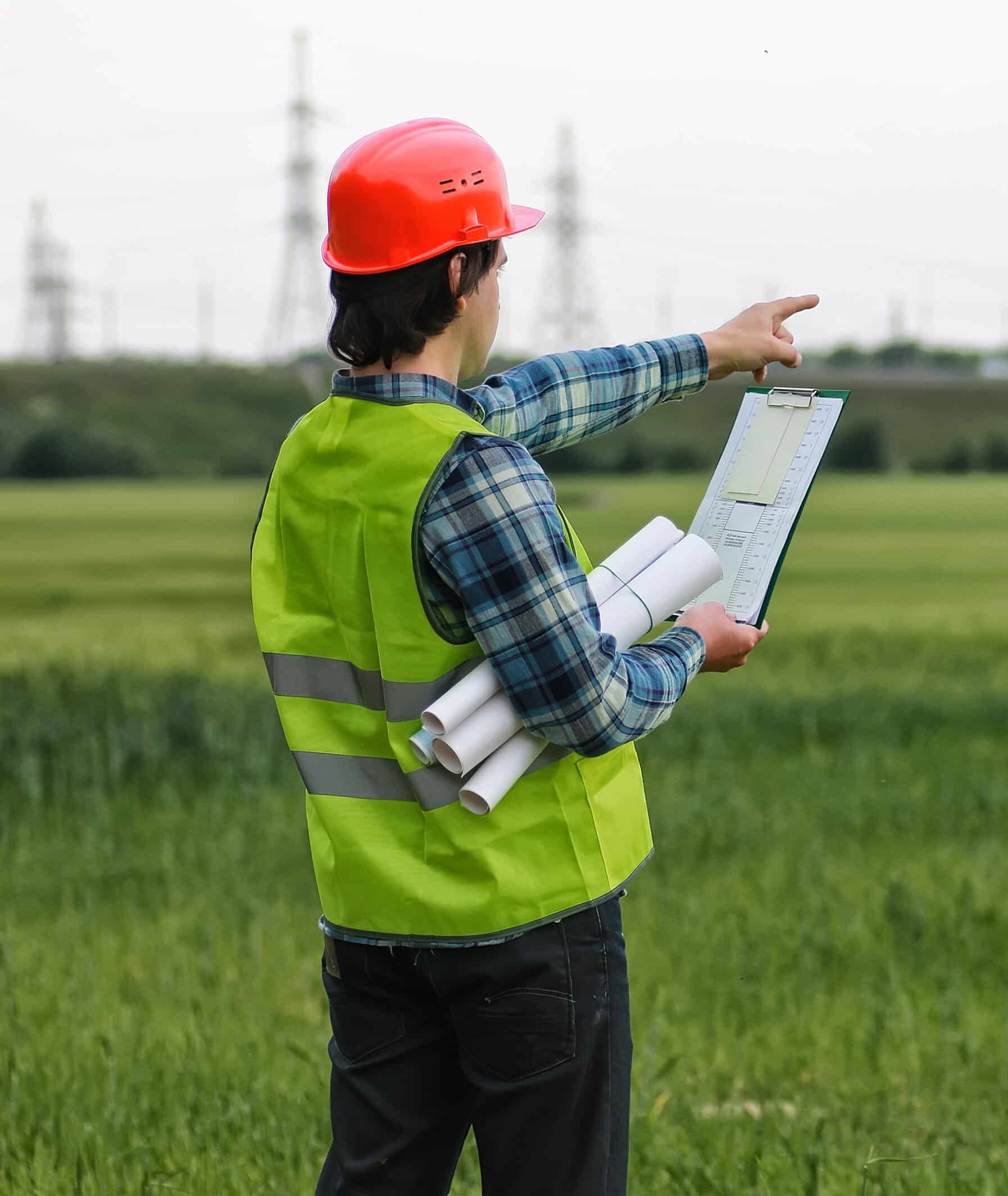 White Land Developer worker in protective clothing and an orange helmet on workplace