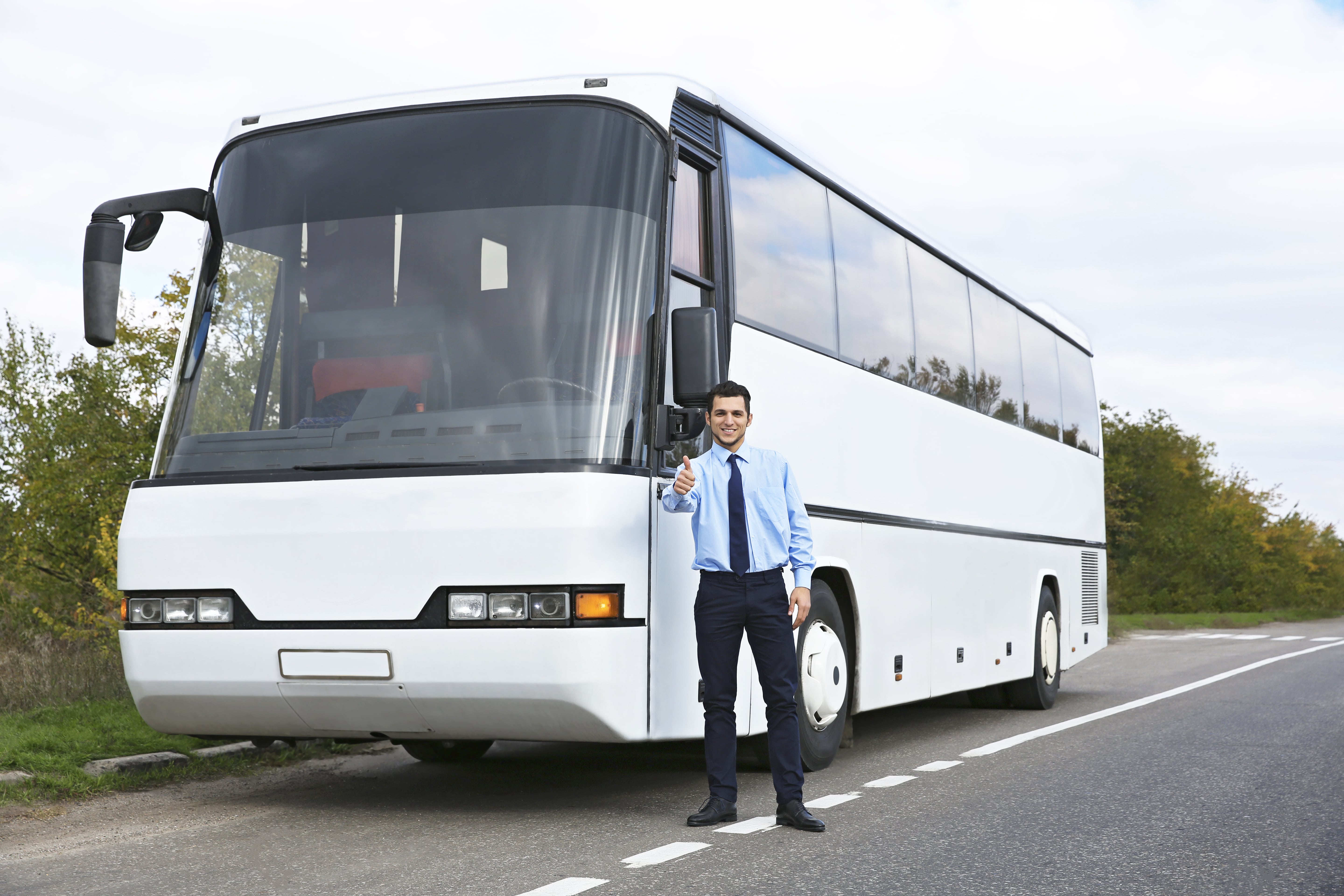 Driver standing in front of bus