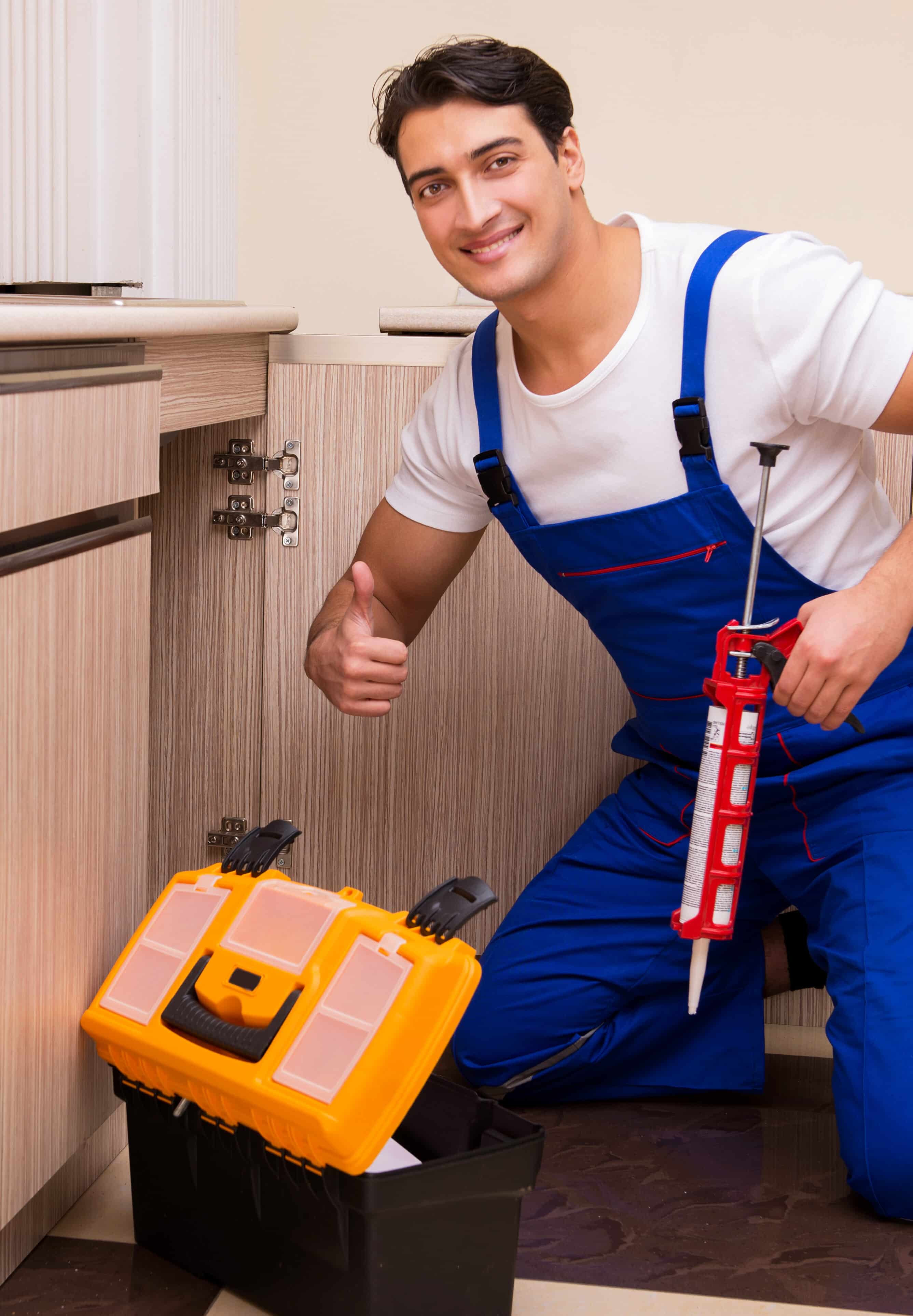 Young repairman working at the kitchen- Young repairman working at the kitchen Service