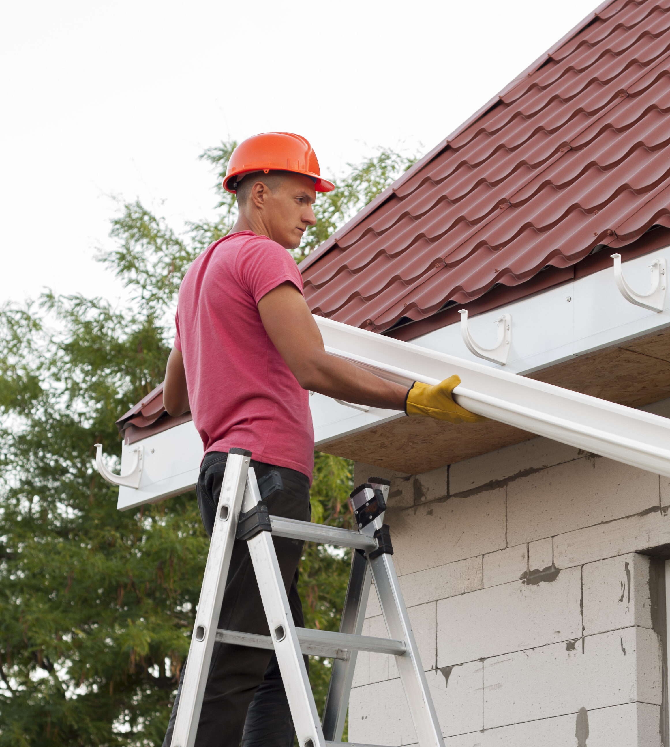 Portrait of a worker repairing the gutter system on the roof