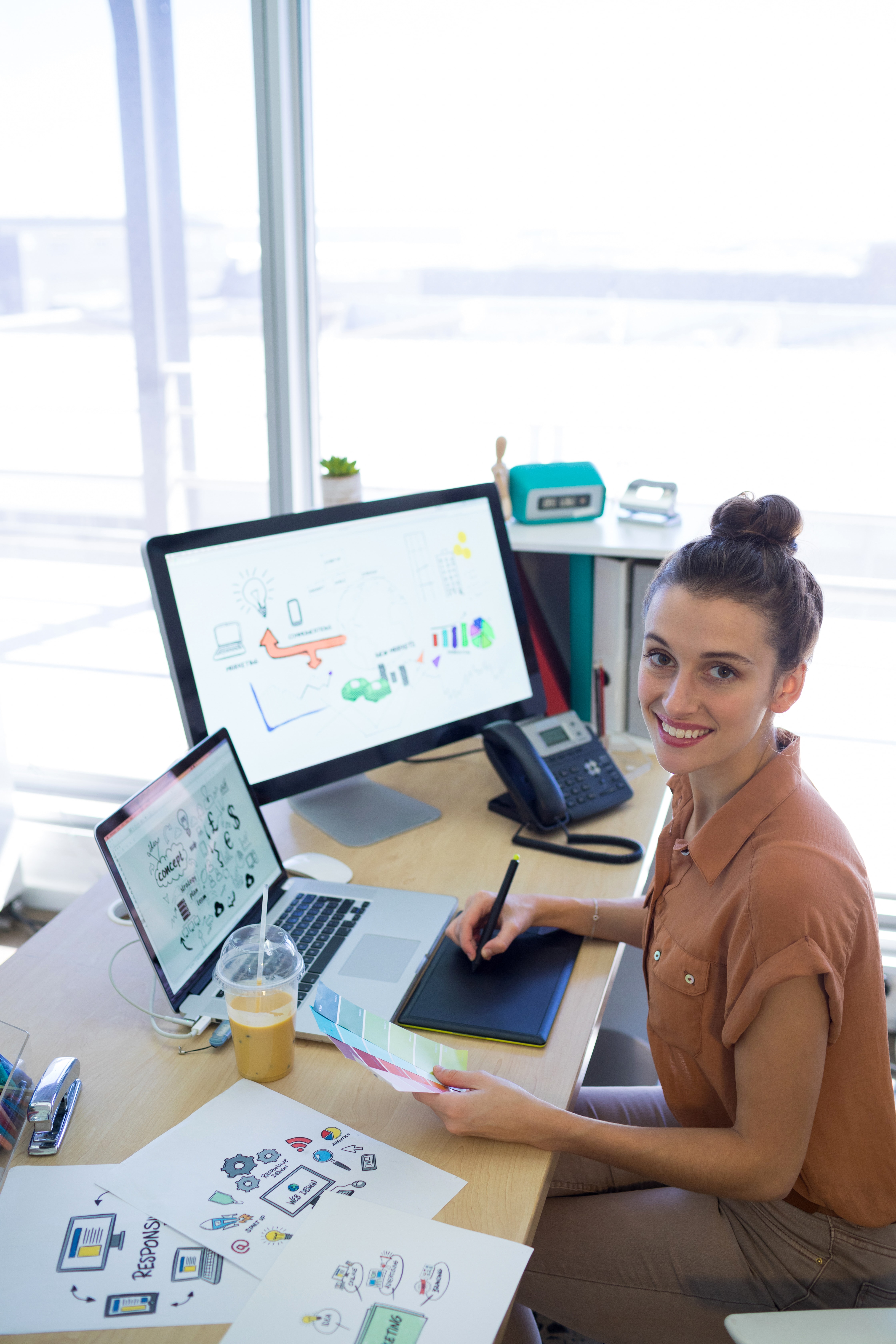 Portrait of female Website Design working over graphic tablet at her desk in office