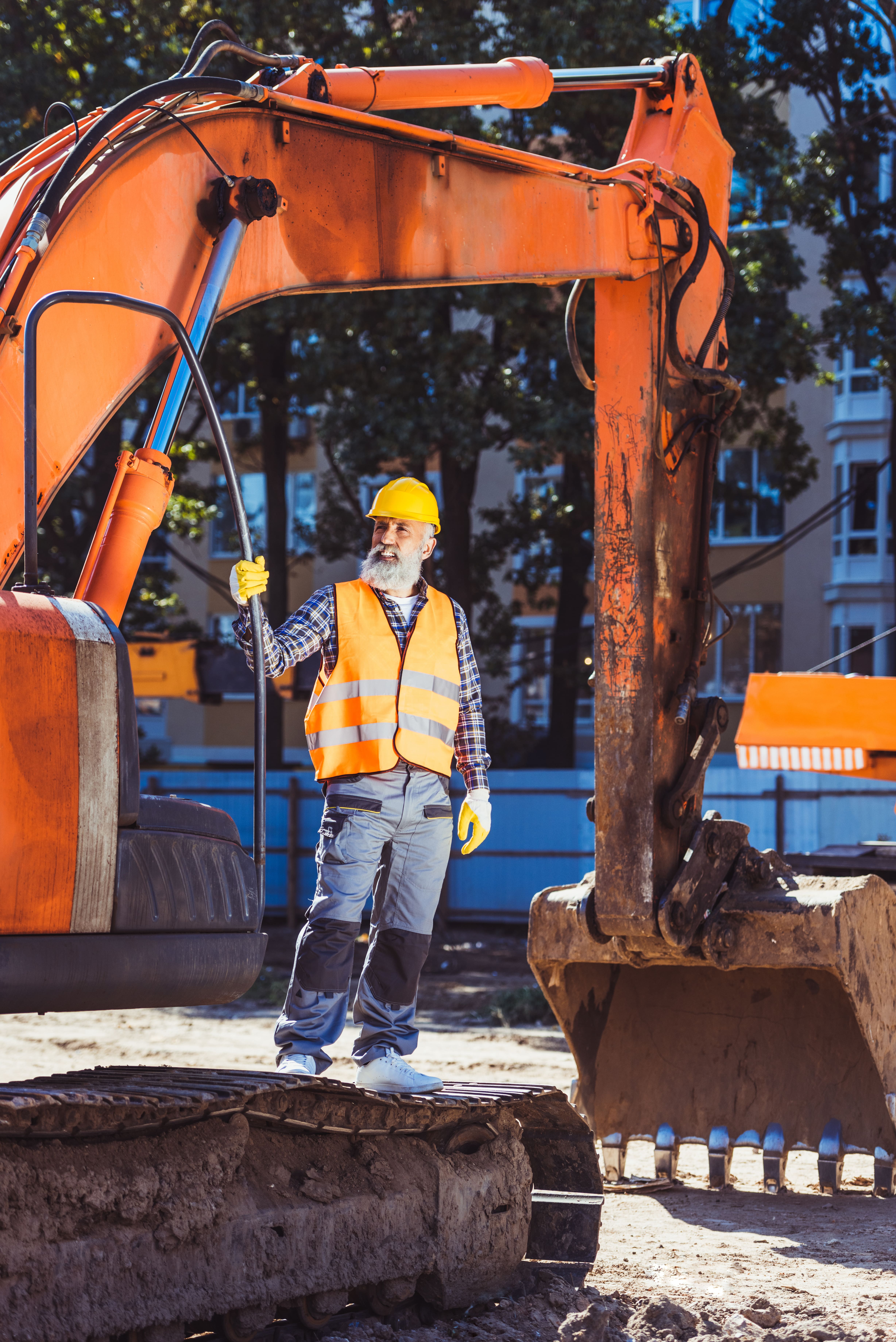 Portrait of a Construction worker posing with excavator cleaning land doing some Groundworks