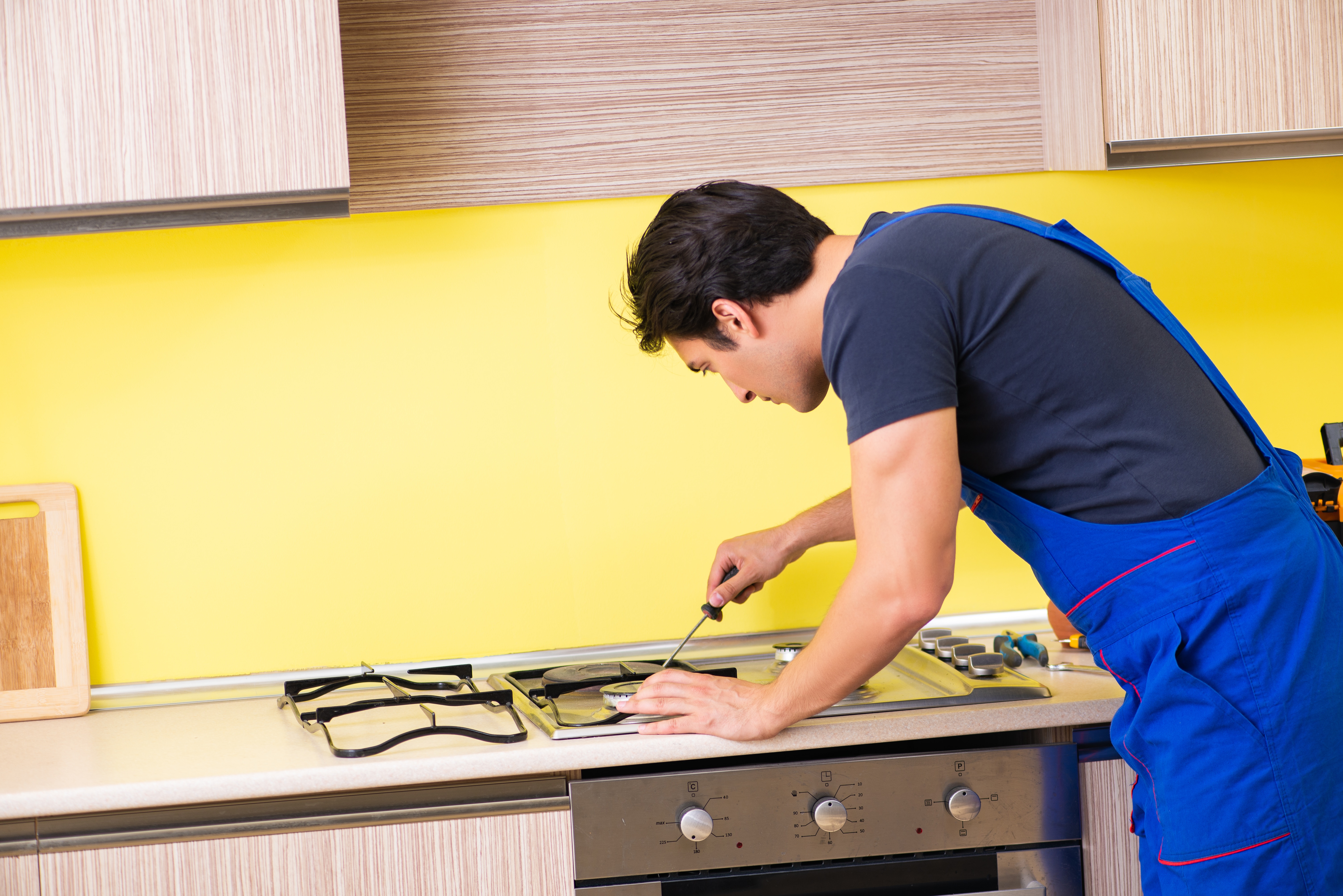 Young Stove Repais man contractor in a blue overall