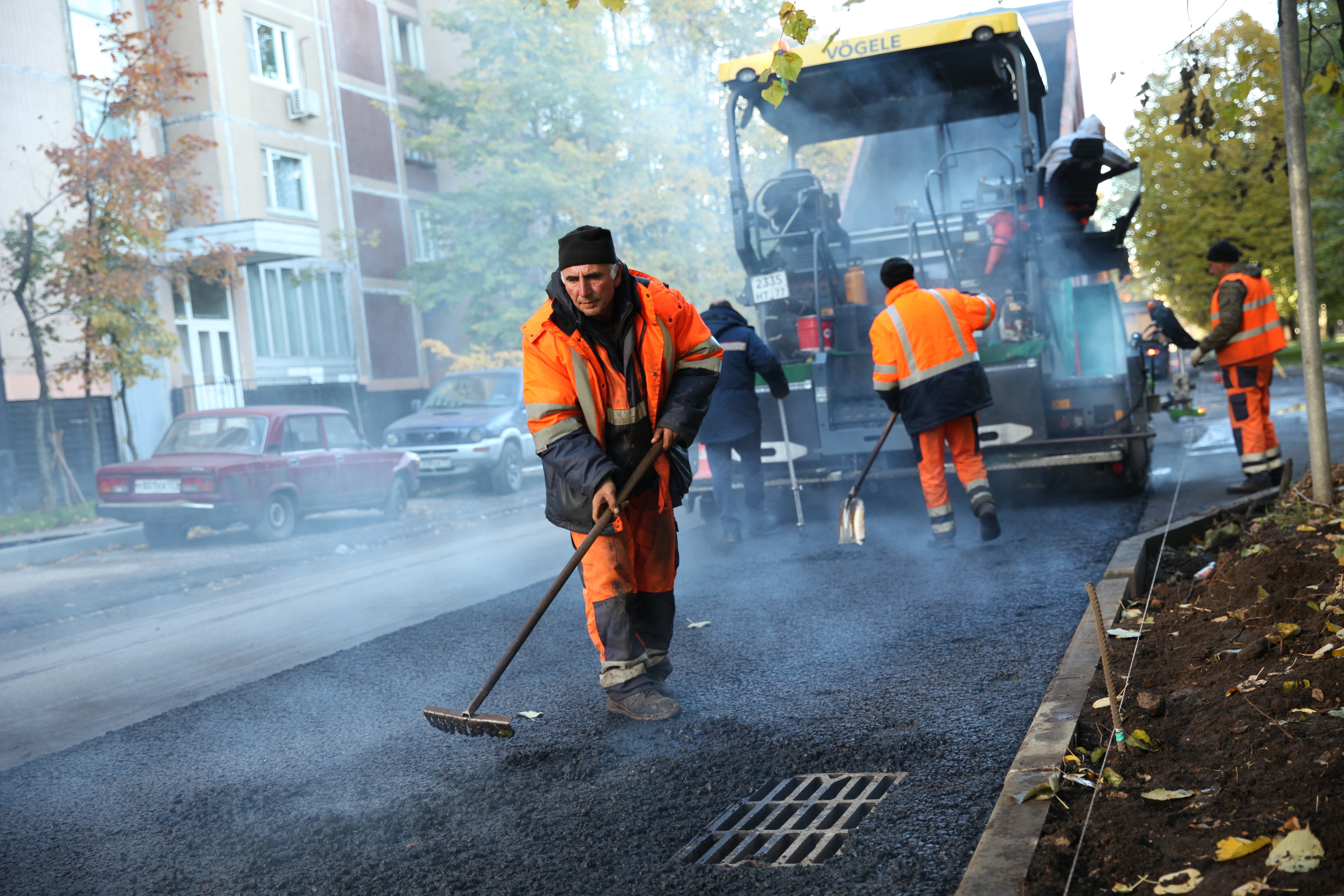 Portrait of Road builders laid asphalt on the road doing a paving service