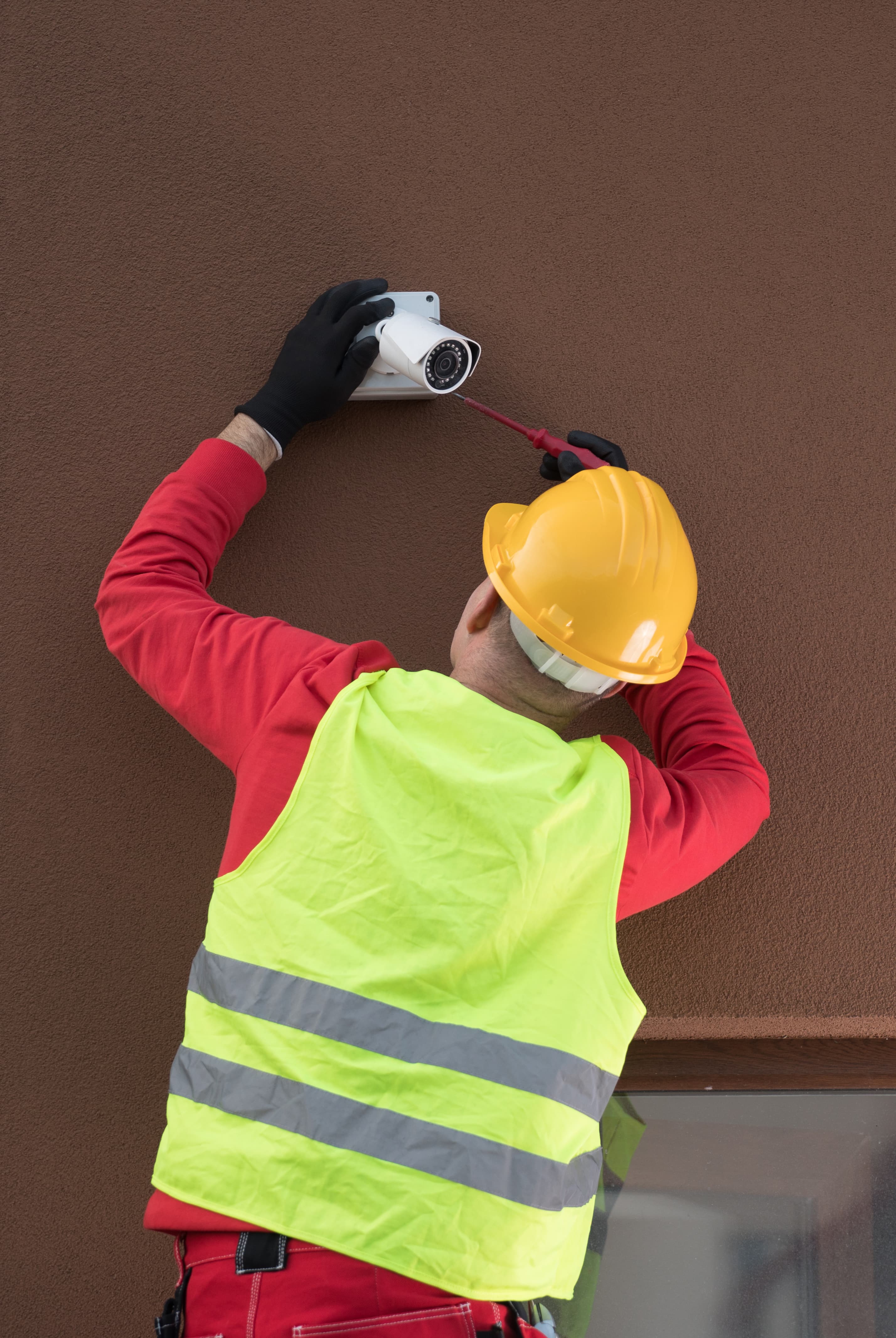 Professional cctv technician working.Technician repair Camera On Wall