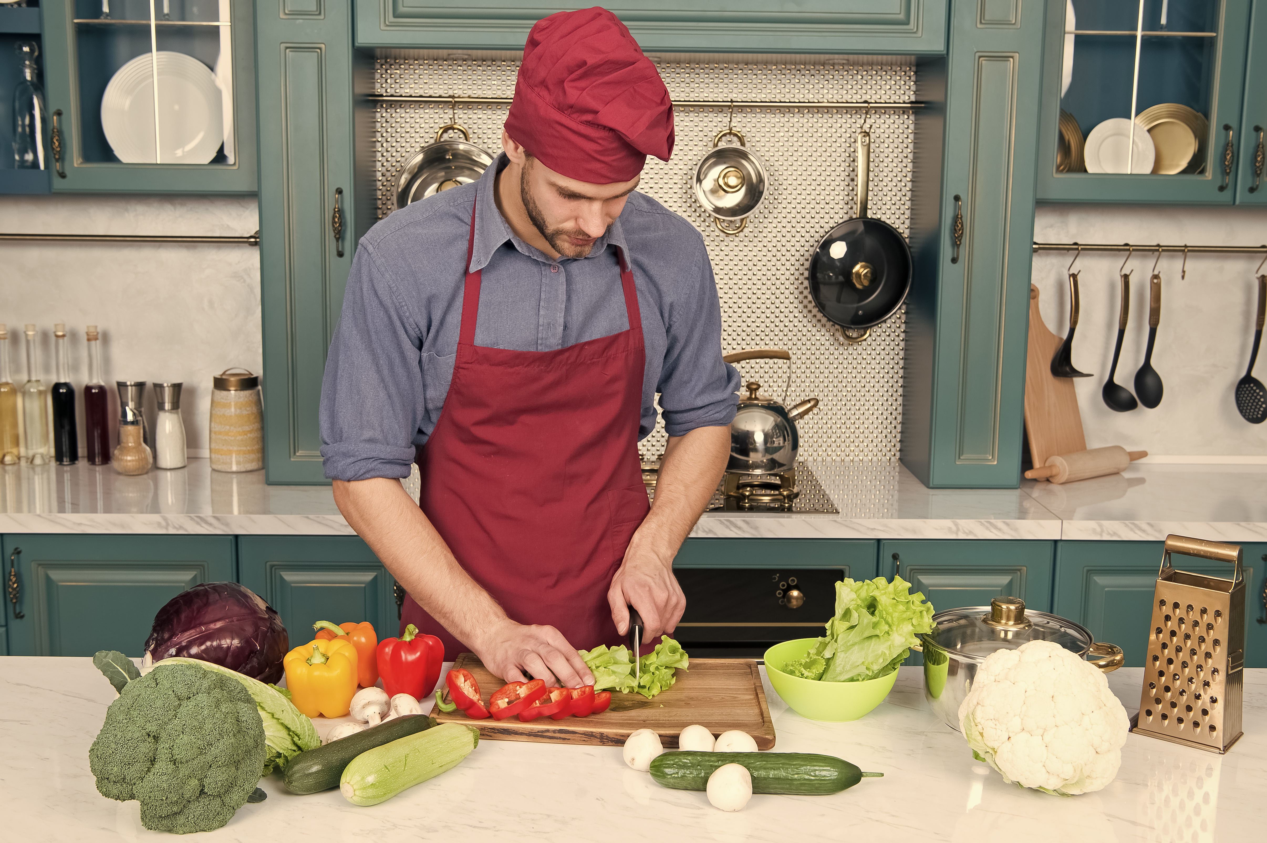 Portrait of a Private Chef cooking vegetarian recipe. Man chef wear apron cooking kitchen. Man cook vegetarian recipe with fresh vegetables. Pick fresh vegetables. Vegetables main ingredient. Recipe with fresh vegetables.