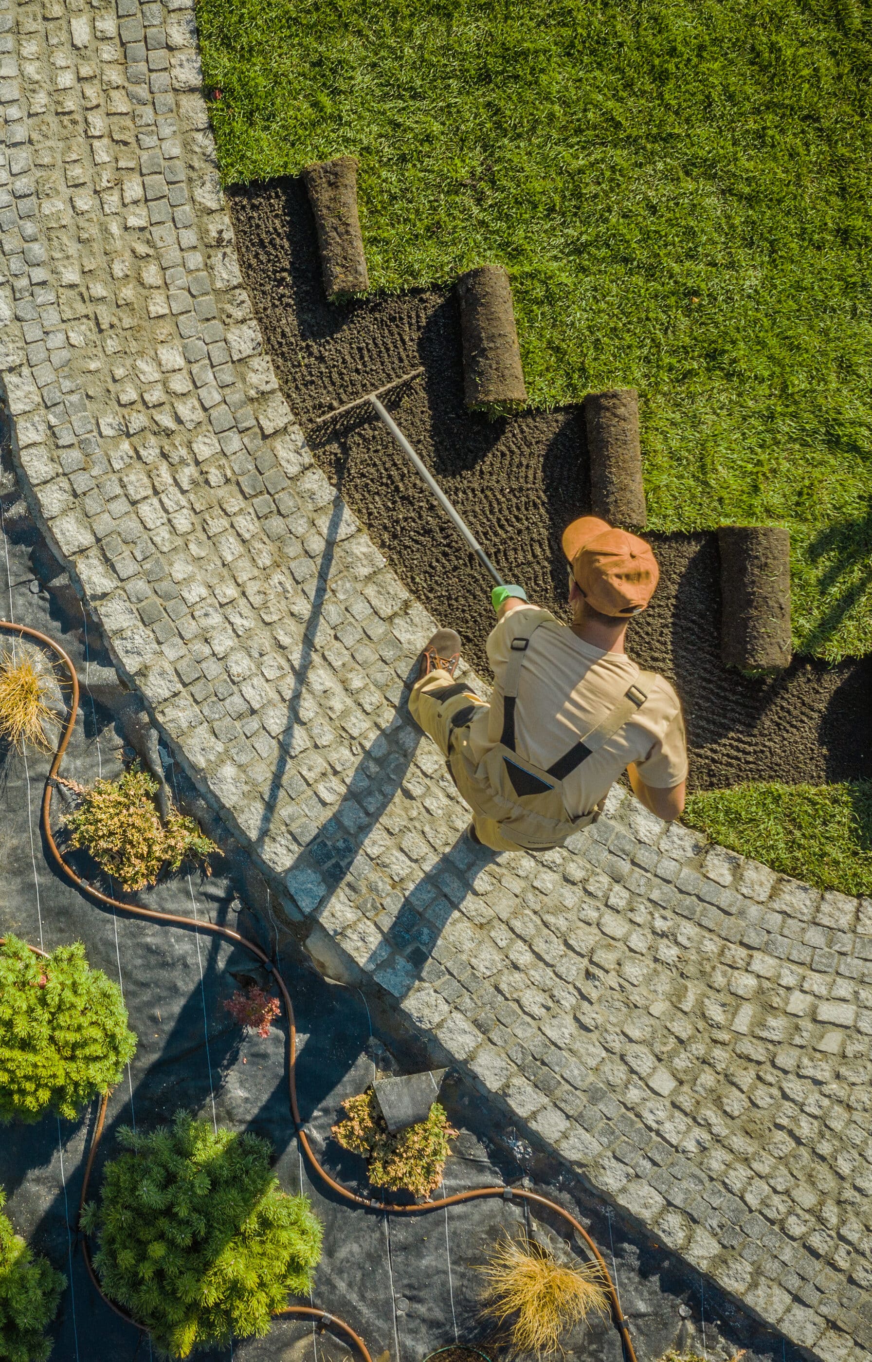 Aerial View of a Driveway Landscaping Worker. Planting Flowers, Decorative Trees and Natural Grass Installation