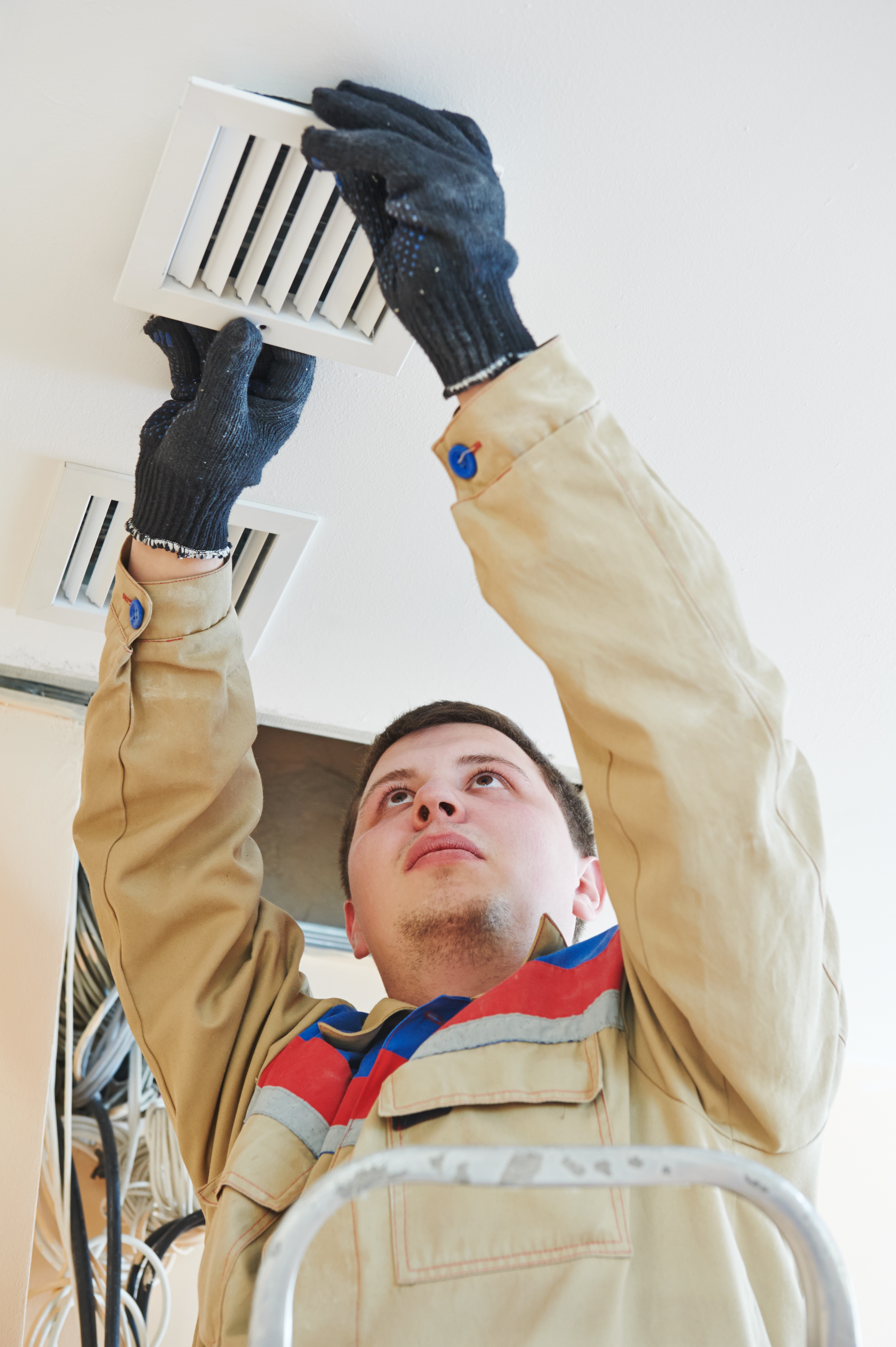 Portrait of a industrial builder installing ventilation in the ceiling