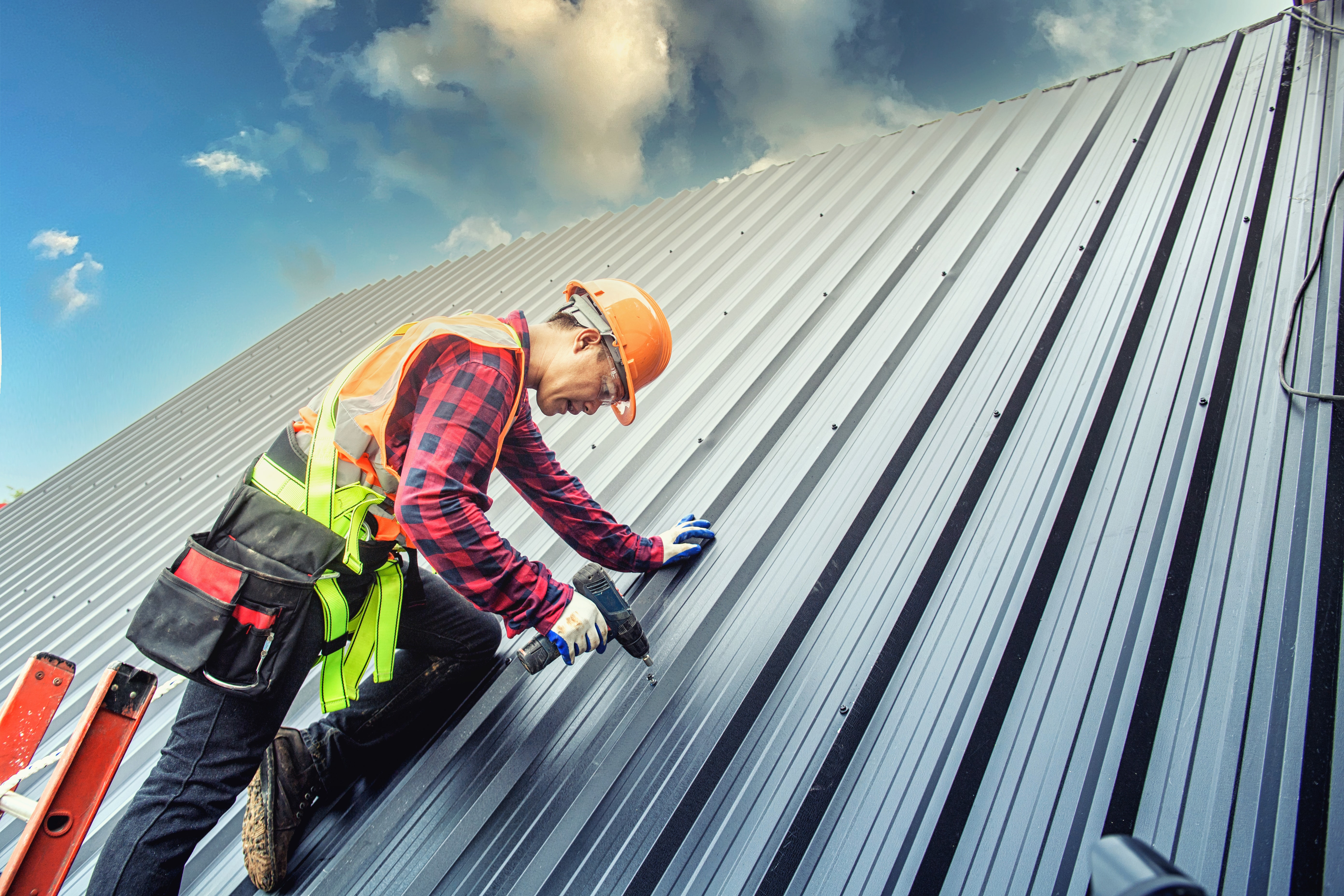 Worker man building tradesman on the roof of a house  with safety helmet, new home, construction concepts Metal Roofing - Selective focus. vintage film grain filter effect styles