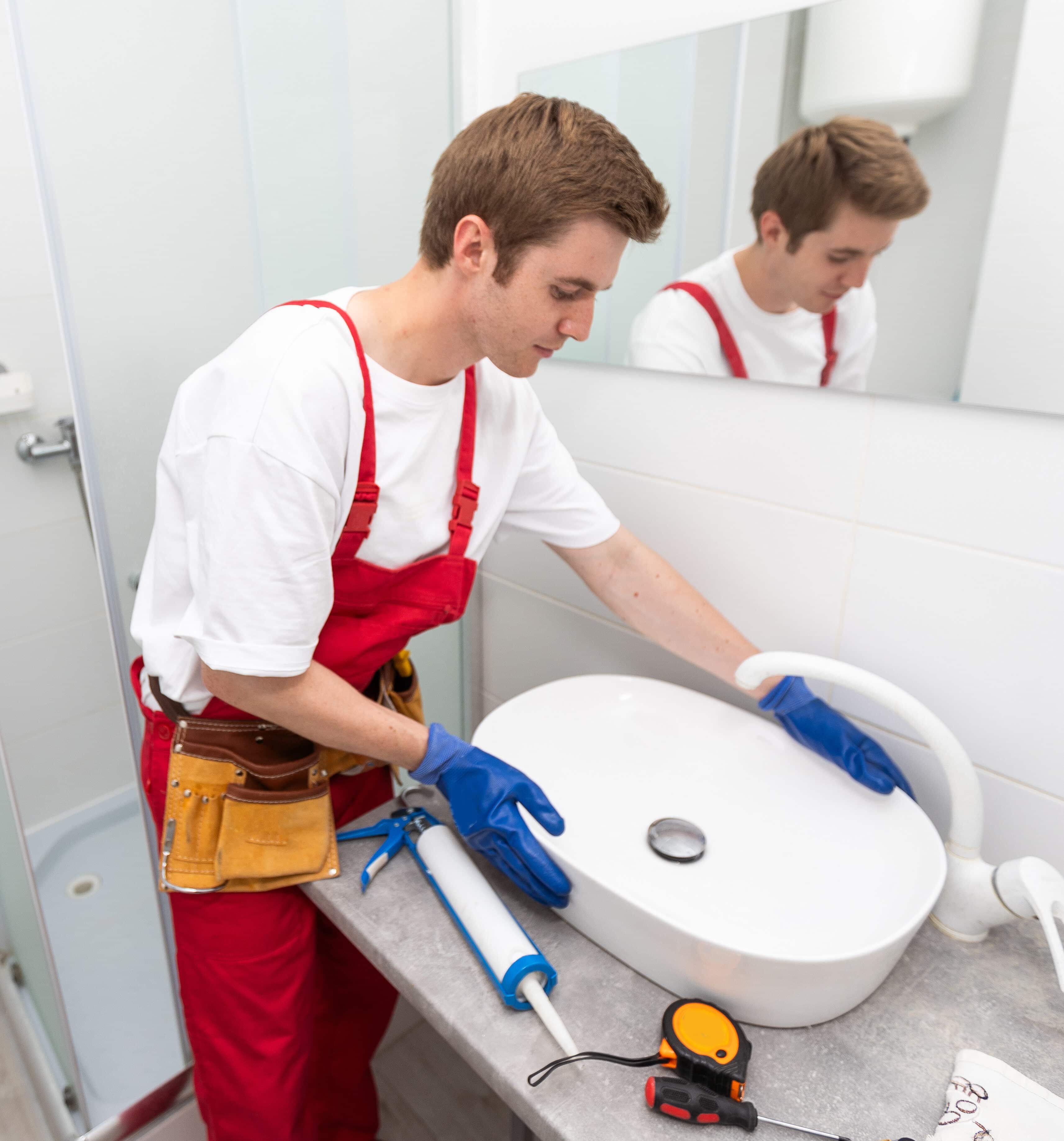 a worker installs a wash basin in a bathroom