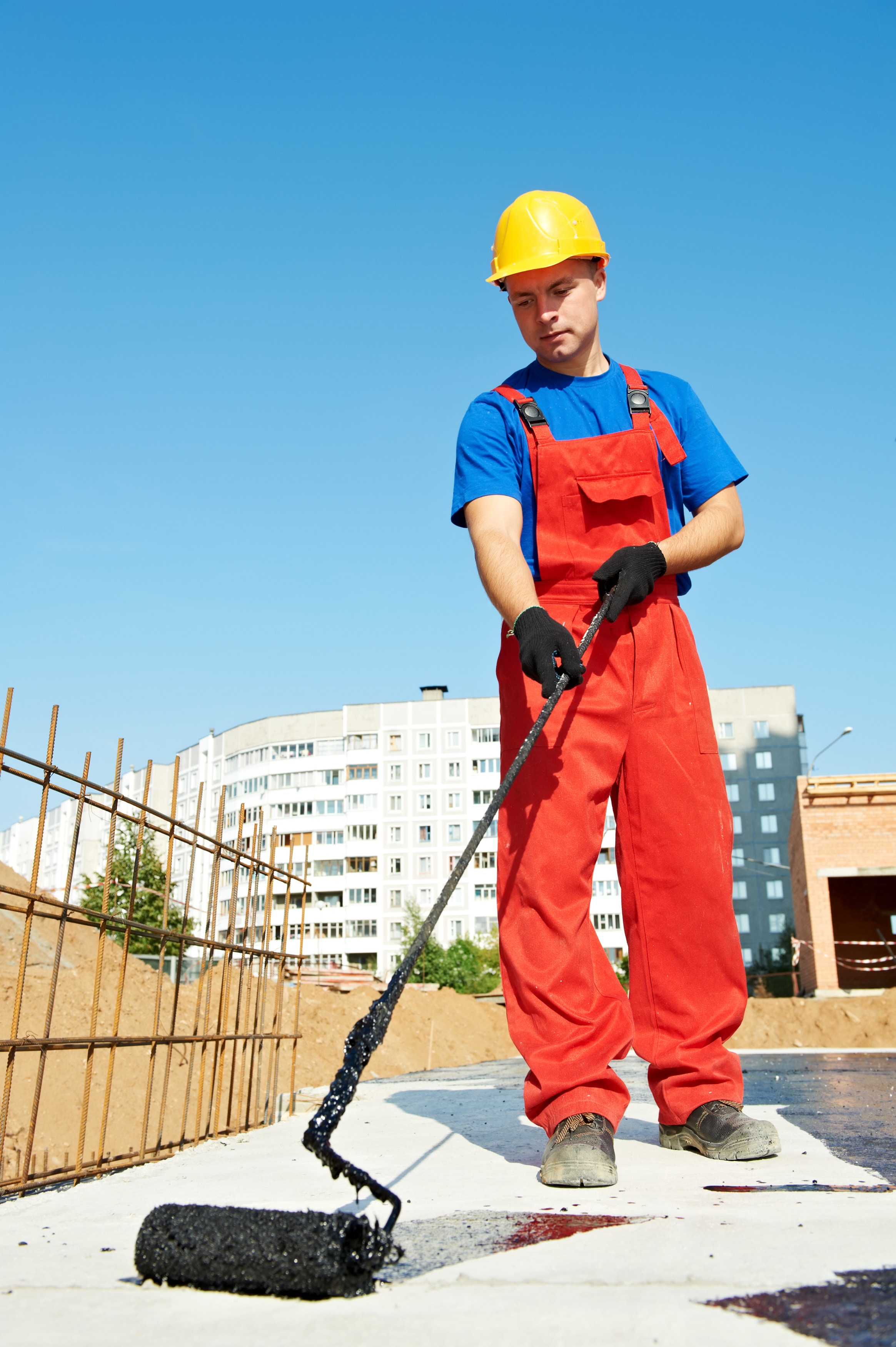 builder worker in uniformcovering roof with Waterproof painting at construction site