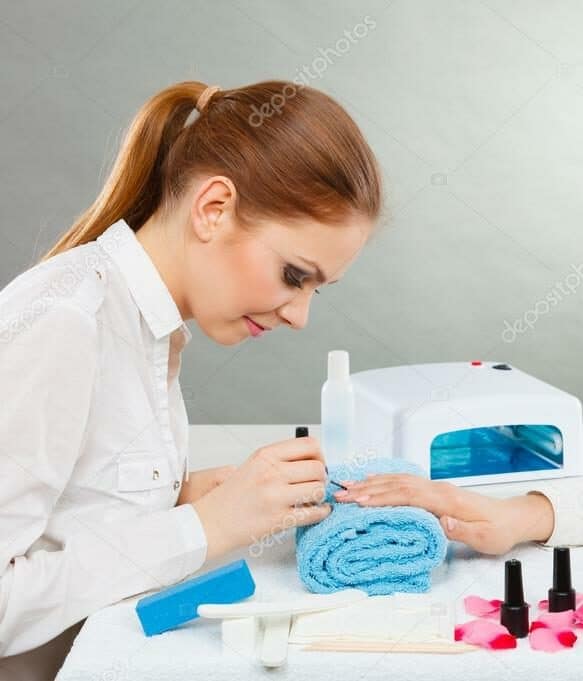 Professional manicurist painting woman nails.