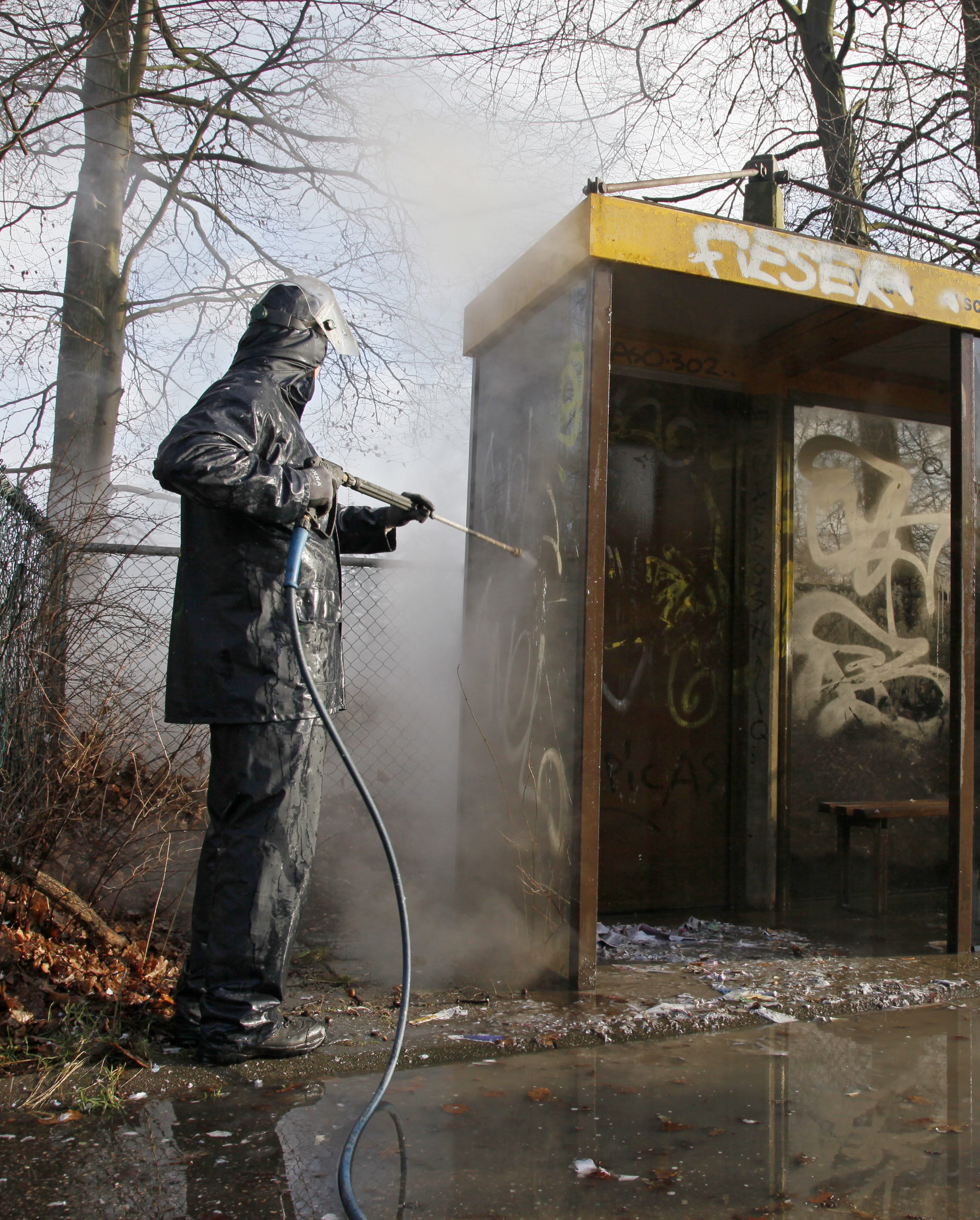 Portrait of a Man Removing graffiti from bus stop