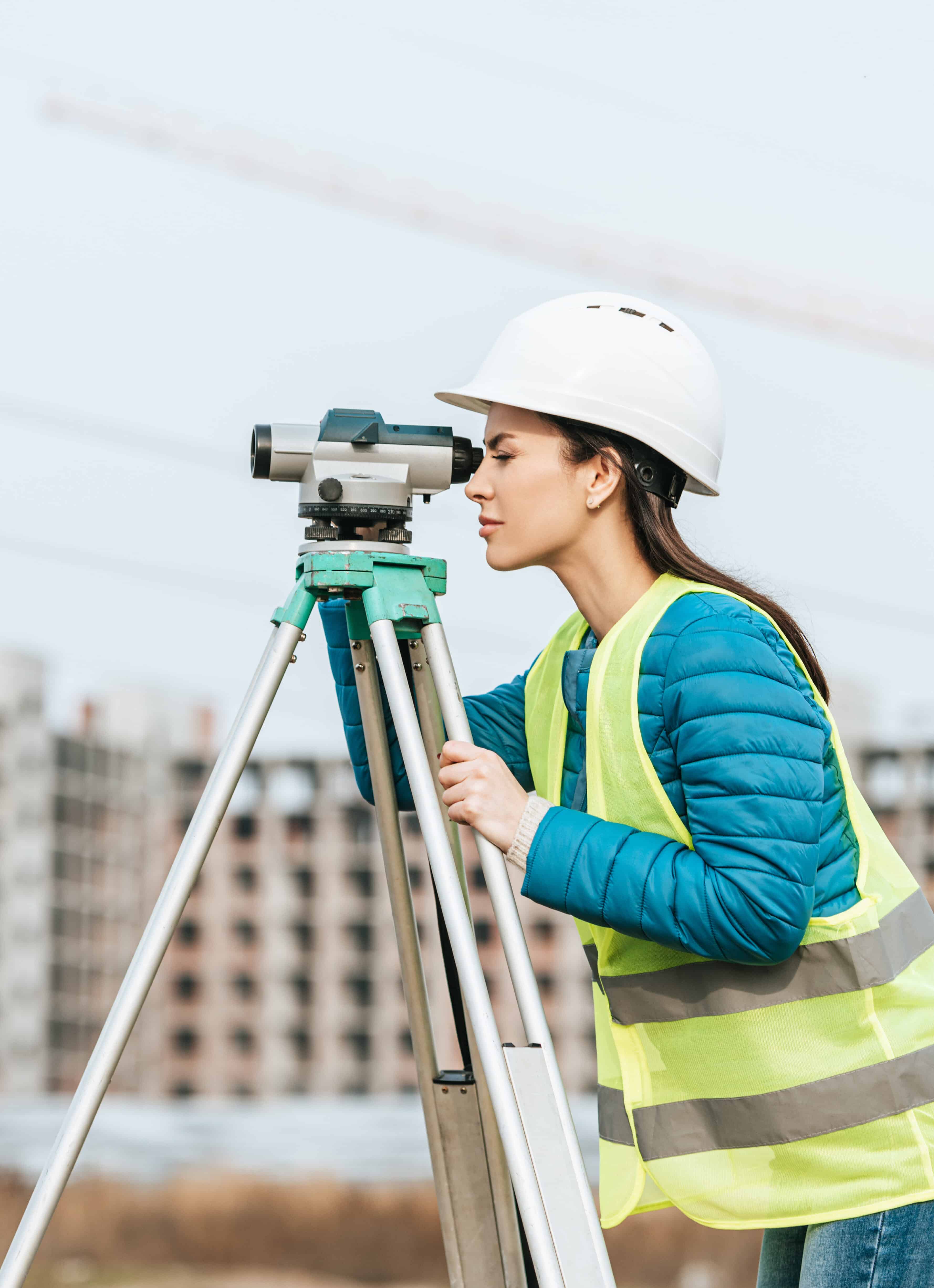 Side view of Surveyor measuring land with digital level