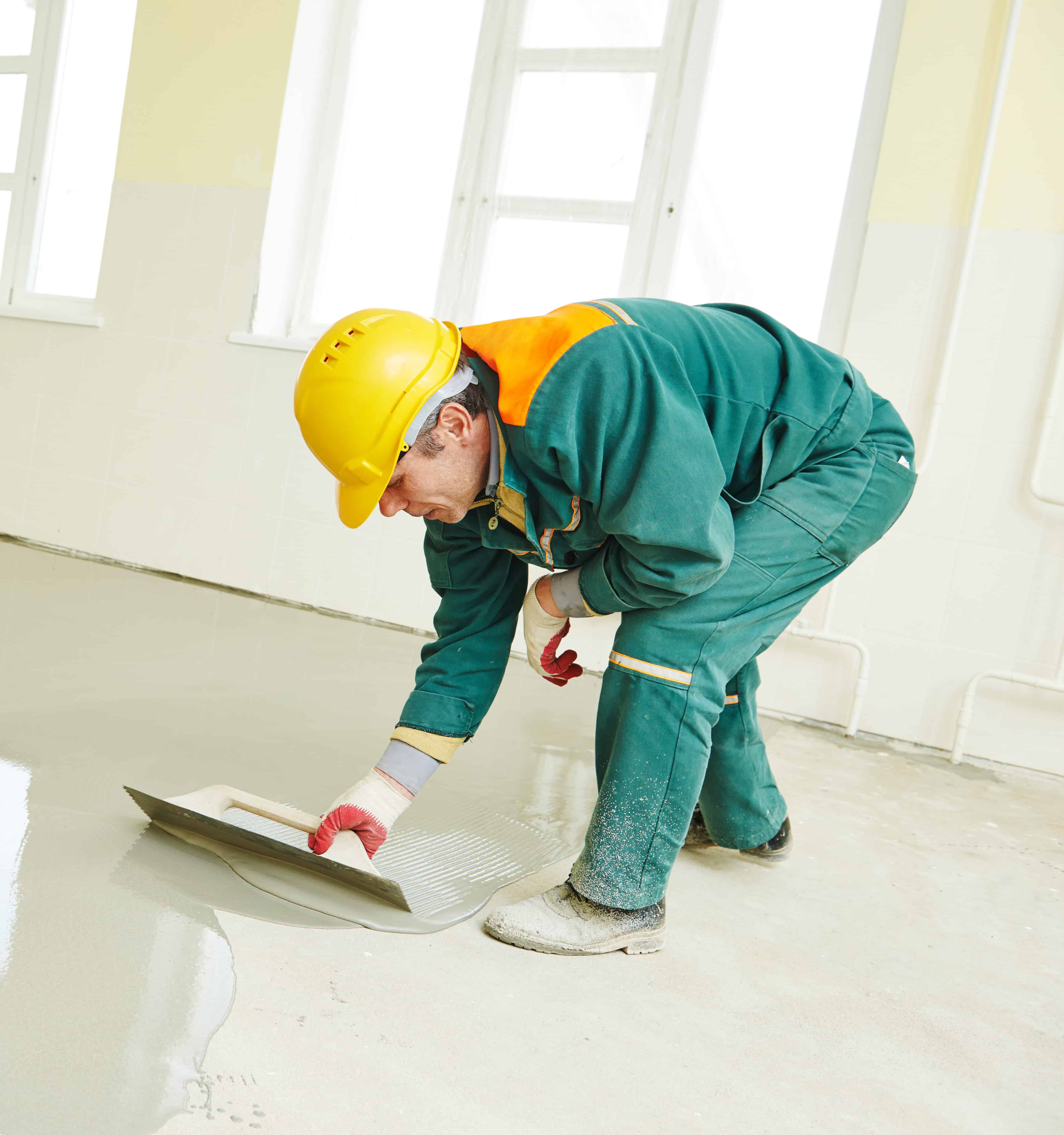 Specialist during floor covering works with self-levelling Micro Cement Specialist