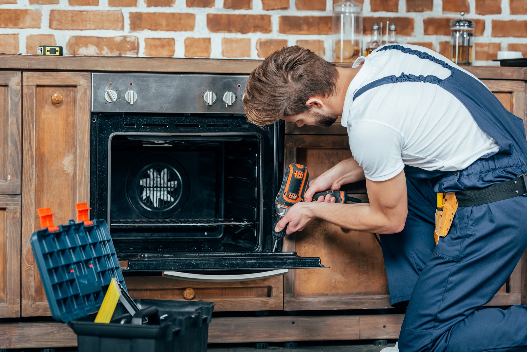 Portrait of a Man Installing a cooker into a kitchen