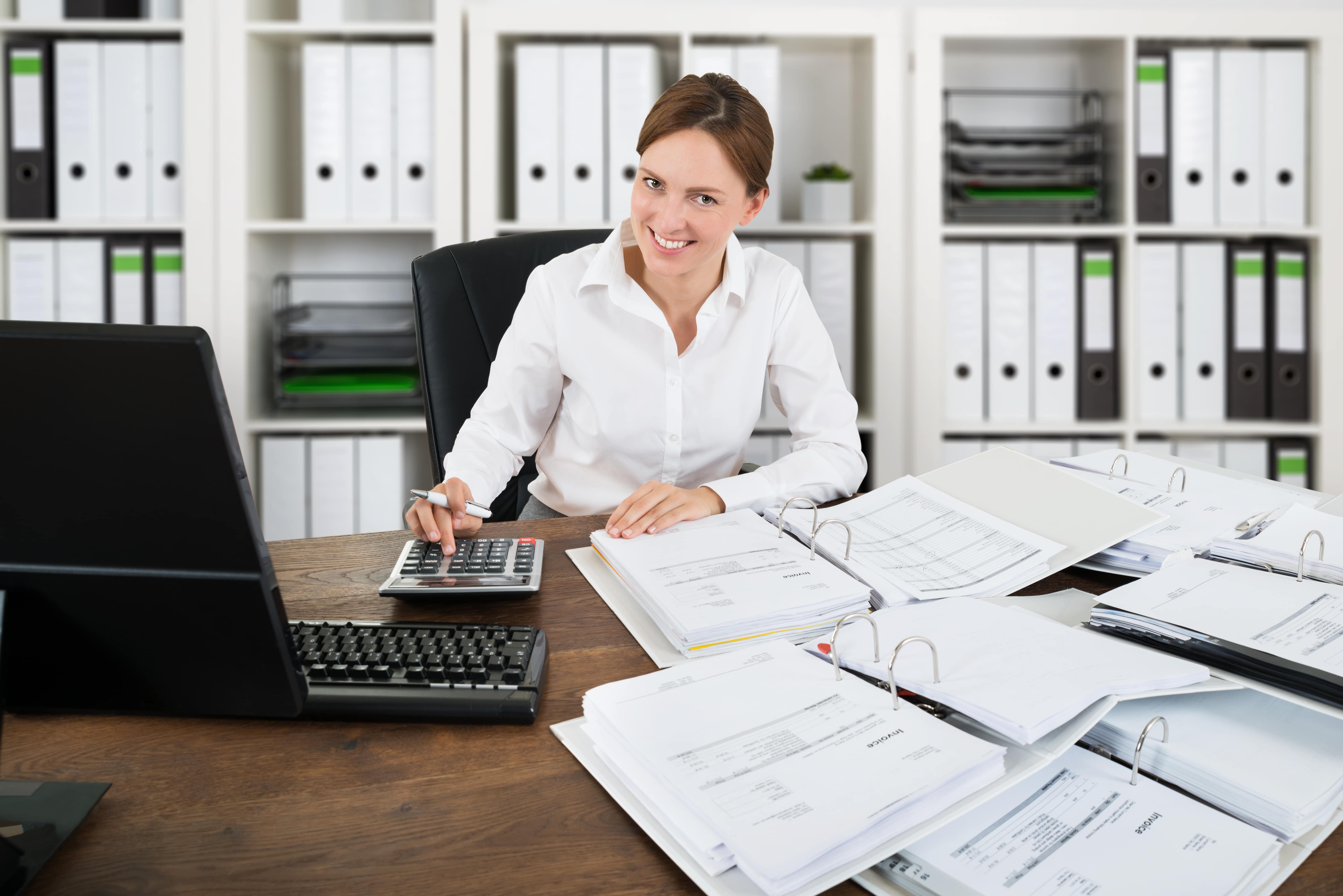 Portrait Of A Happy Accountant Woman Calculating Invoice