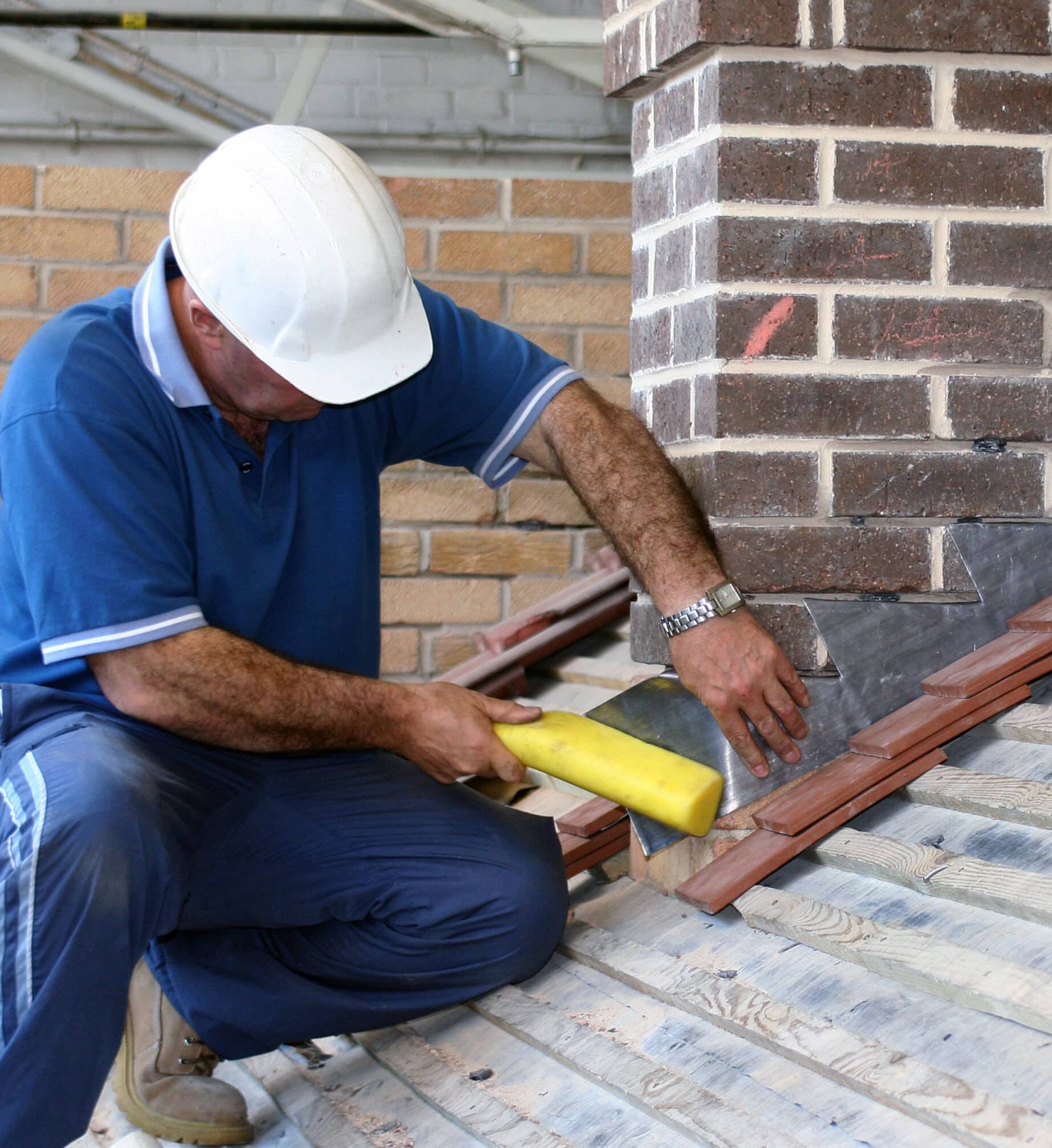 Trainee roofer learning how to tile a roof properly. Lead Flashing