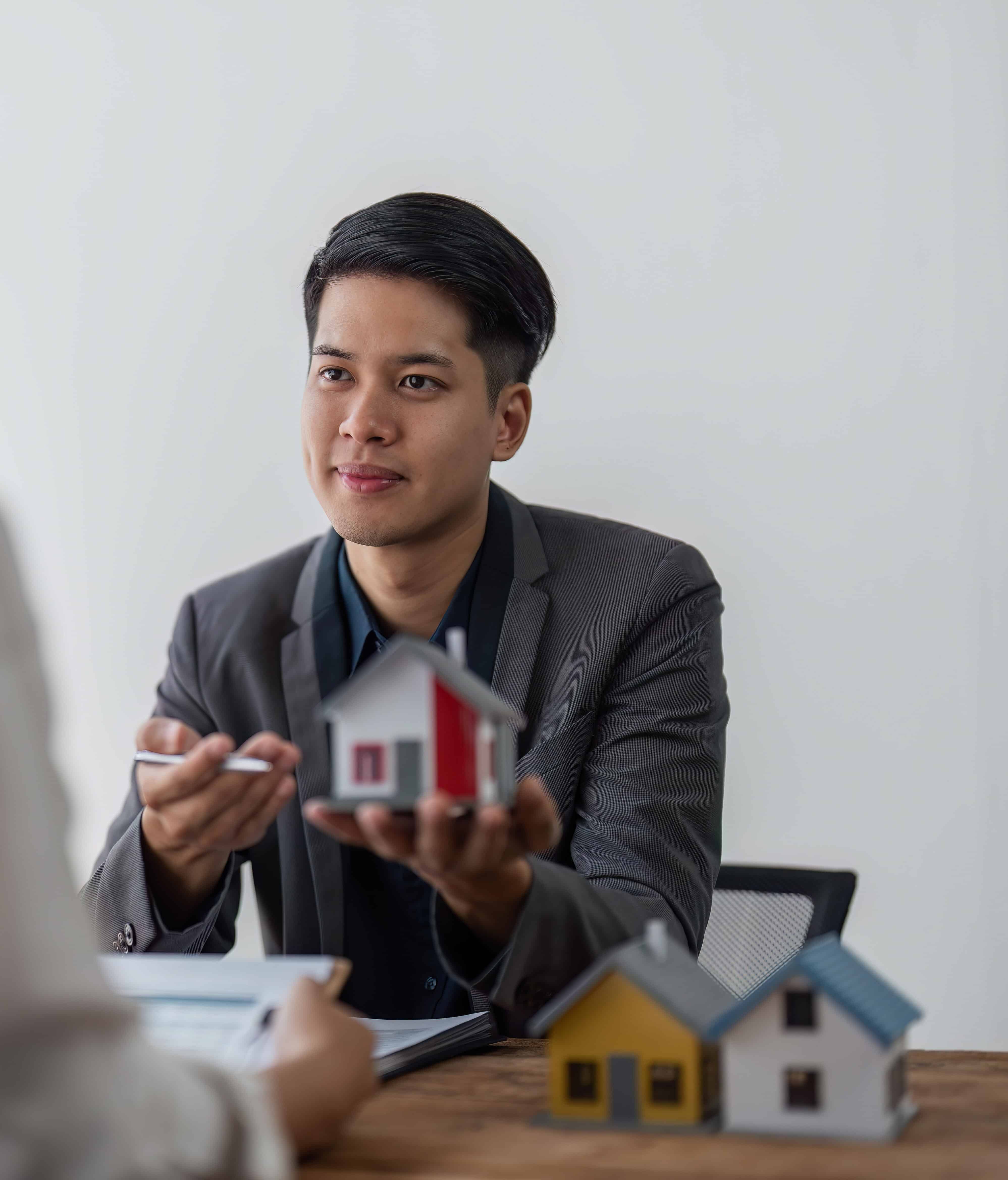 Mortgage Advisor holding house to his client after signing contract, concept for real estate, moving home or renting property